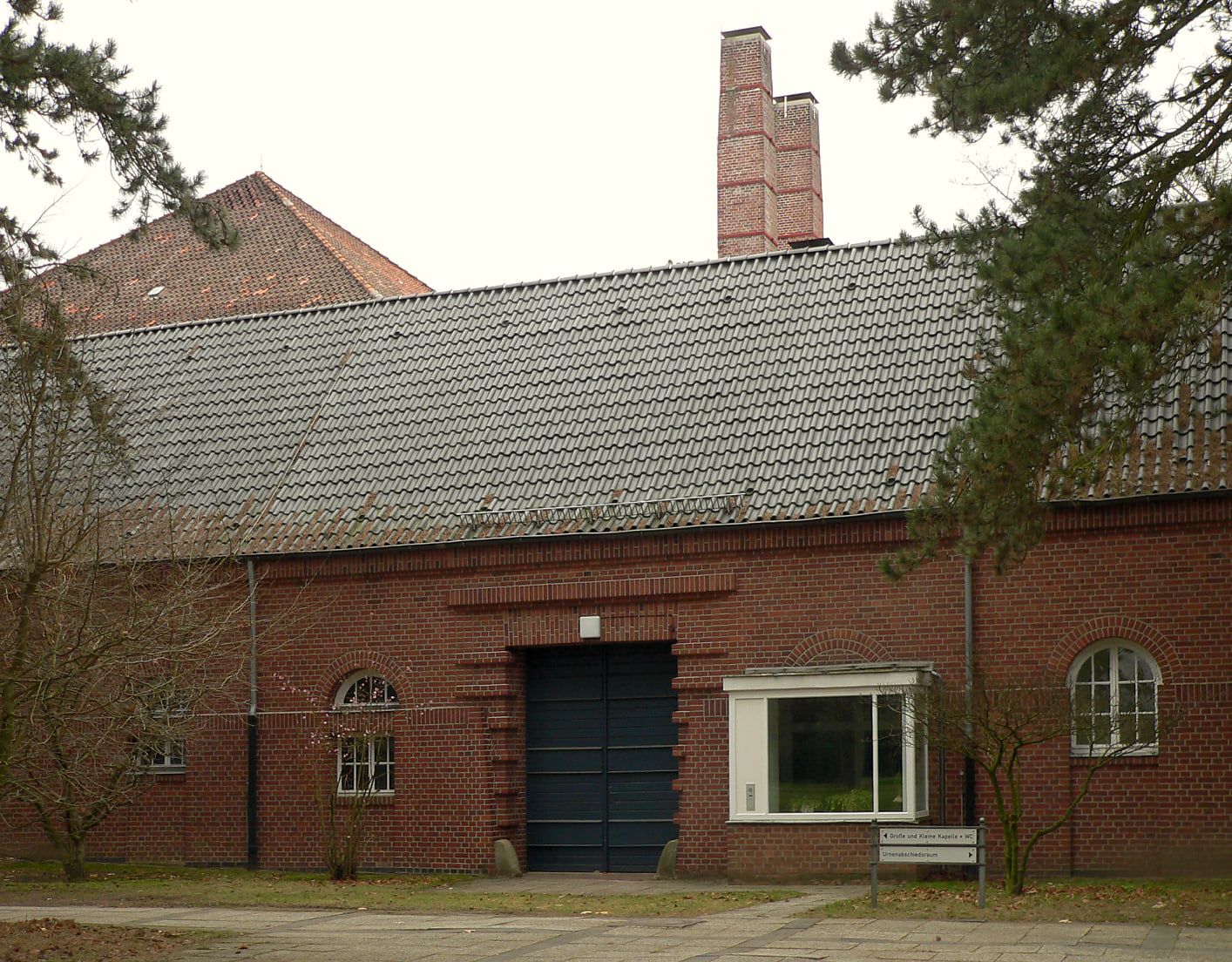 Langgestrecktes Backsteingebäude mit Walmdach und hohem Schornstein auf Stadtfriedhof Seelhorst